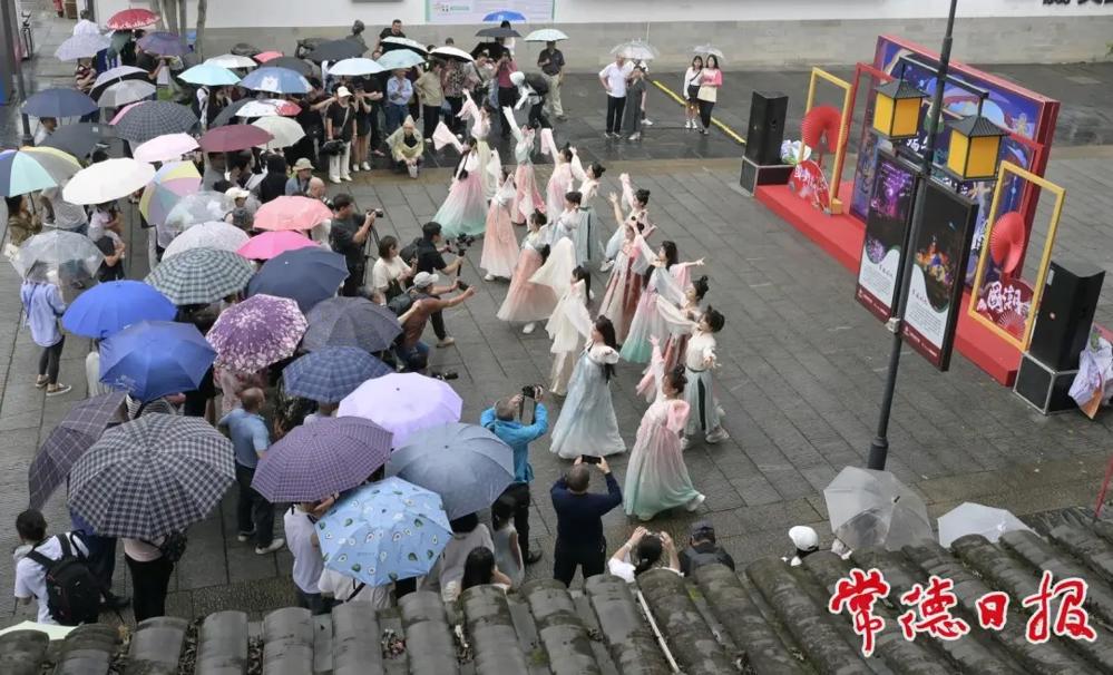 2024年端午期间，澳门新葡新京在线国风表演吸引到众多游客撑伞欣赏。（常德日报媒资库）