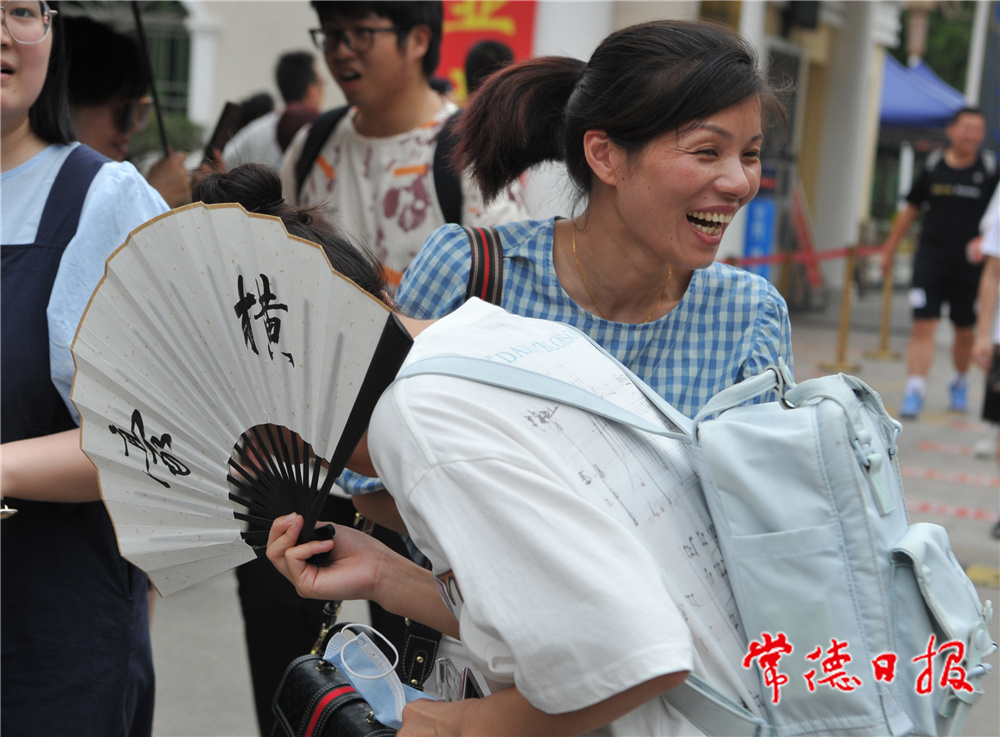 6月9日，在常德市一中考点，中午下考后，一名考生拿着一把写着